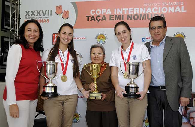 Stella Bihar (esq.), Emi Nomura (centro) e Mauro Batista (dir.) entregam troféus às campeãs