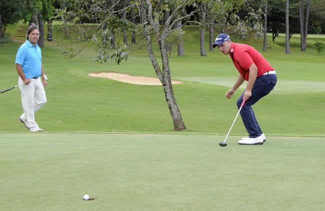 Luis Thiele emboca no buraco 16 de Brasília, observado por Fanta: bons putts o garantirma como nº 1 do golfe brasileiro esta semana