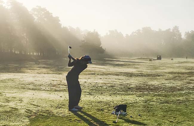 Luiza se aquece no driving range com o sol nascendo e temperaturas abaixo do 5º C