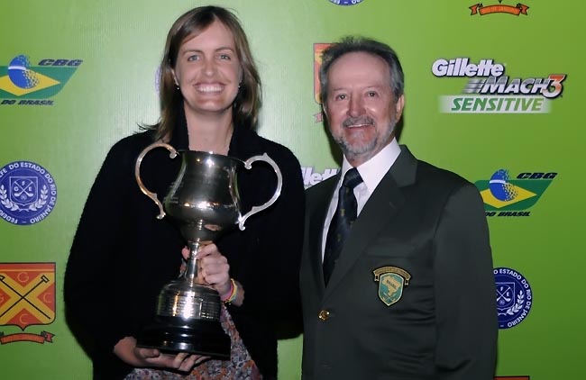    Mary recebe troféu de campeã de Paulo Pacheco, vice-presidente da CBG: tricampeonato