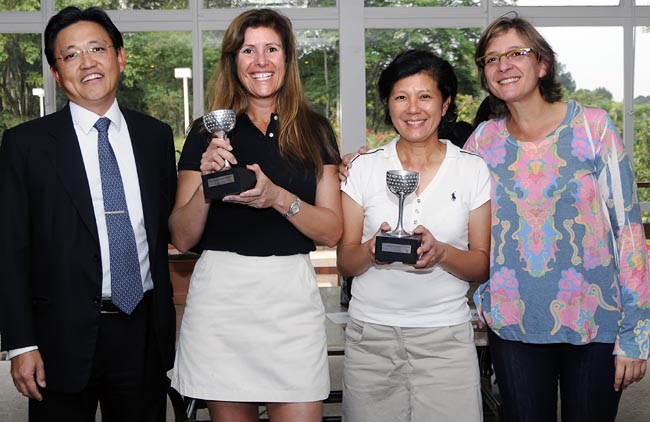 O diretor de golfe Jorge Saeki e a capitã Vivian Golombek entregam o troféu às campeãs