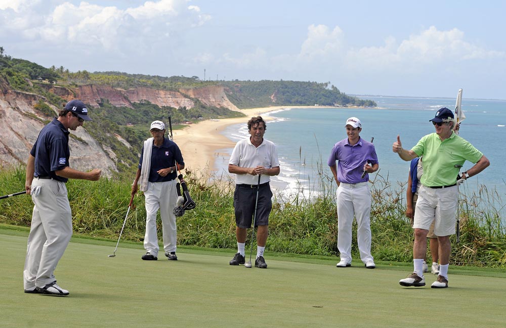 Barcellos comemora birdie no 14 para jogar oito abaixo, observado por seu caddie, Christian da Costa, Daniel Stapff e Reinold Geiger, da L´Occitane